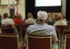 Audience members seated facing a presentation screen