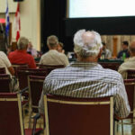 Audience members seated facing a presentation screen