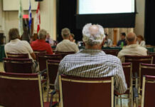 Profanity, Threats, Chaos – In City Hall Audience members seated facing a presentation screen
