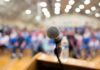 microphone on a podium facing a blurred audience