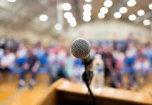 microphone on a podium facing a blurred audience