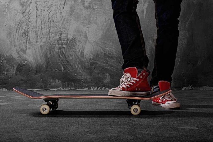Person standing on a skateboard wearing red sneakers