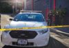 Seven Shots, One Child, and Unanswered Questions Aaron Guiel near police car behind yellow caution tape