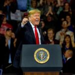 Price Pain, Trump Gains In Iowa Donald Trump speaking at a rally behind a presidential podium