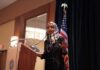 Ilhan Omar speaking at a podium with a microphone