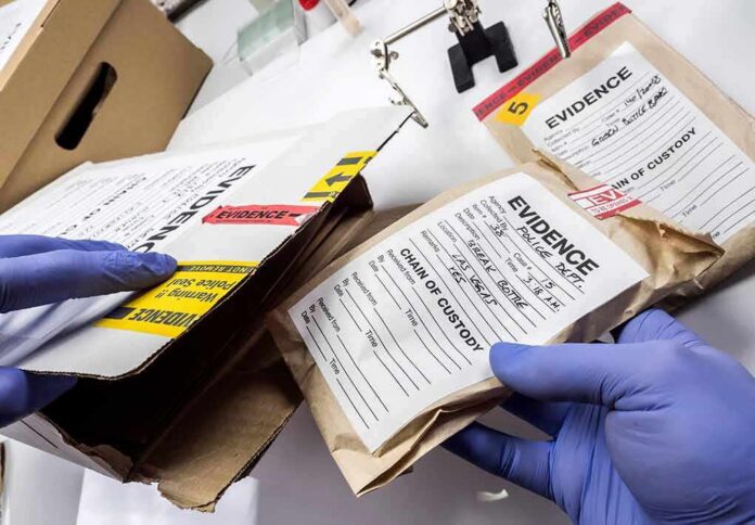 shutterstock_1400793416 Gloved hands handling labeled evidence bags and boxes