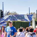 Crowd walking past a Disneyland Resort entrance sign