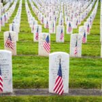 Confederate Monument Comeback – Why Now? Rows of grave markers adorned with American flags in a military cemetery