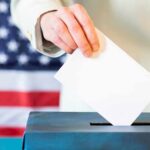 Hand placing ballot into a box