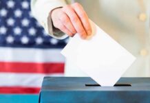 Hand placing ballot into a box