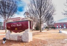 City Hall sign in front of a red-brick municipal building