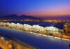 Airport terminal at dusk with illuminated wave-like roof