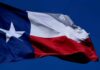 Texas flag waving against a clear blue sky