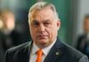 Viktor Orbán in a dark suit with an orange tie at an event