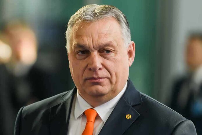 Viktor Orbán in a dark suit with an orange tie at an event