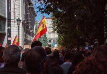 Left Coalition Cracks After Housing Uproar Crowd with Spanish flags in a city street