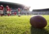 American football on a grass field at a stadium