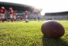 American football on a grass field at a stadium