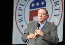 Mike Huckabee speaking on stage with a microphone