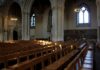 Rows of wooden chairs inside a Gothic church nave