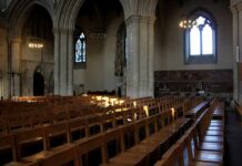 Rows of wooden chairs inside a Gothic church nave