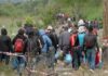 EU Money Trails – What’s Really Moving Migrants? Group of people walking along a rural path carrying bags